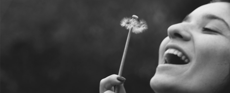 Qué debería valorar un paciente del odontólogo que va a colocarle implantes foto blanco y negro con persona soplando flor