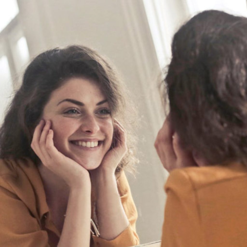 mujer sonriendo al espejo