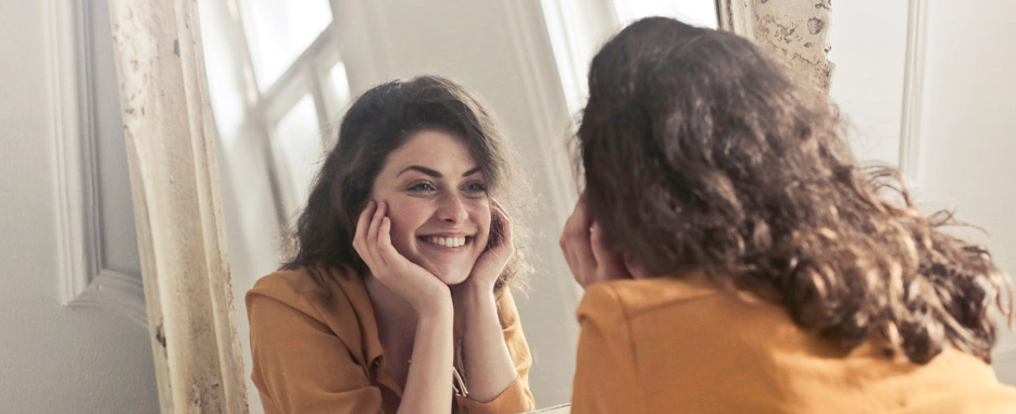 mujer sonriendo al espejo